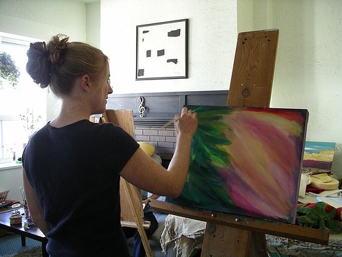 Kendra Dixson (Smith) painting an intuitive acrylic painting at an easel.